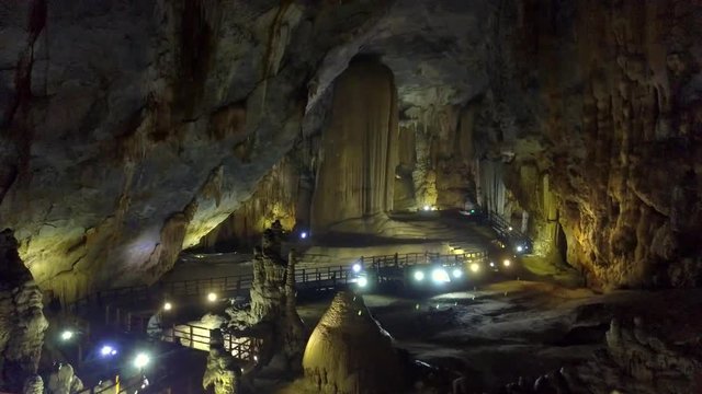 tourist looks at magical structures of karst cave hall