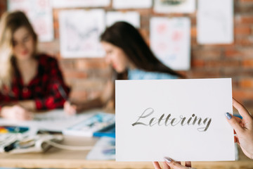 watercolor brush lettering lessons. artful hobby and creative handwriting. woman hands holding...