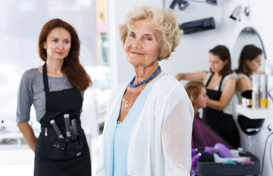 Smiling elderly woman with hairdresser