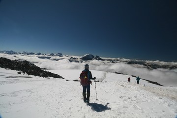 Fototapeta na wymiar Tourist admires the Caucasus mountains from the slopes of mount Elbrus.
