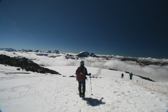 Tourist admires the Caucasus mountains from the slopes of mount Elbrus.