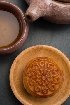 top view studio shoot of traditional Chinese mooncake with tea and teapot on black background vertical composition