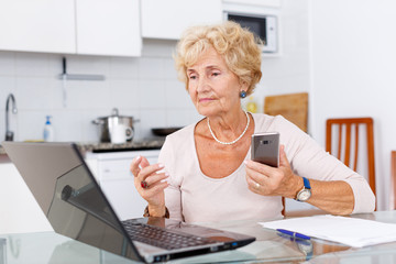 Woman using computer and smartphone