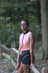 Naklejka na ściany i meble Trendy black woman in shorts and glasses