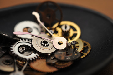 Detail of watch machinery in spoon on the brown wood background.