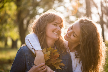 Daughter hugging her mother - autumn season