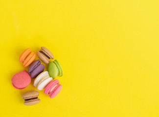 Sweet and colorful french macaroons or macaroon on yellow background, Dessert eating with tea or coffee.