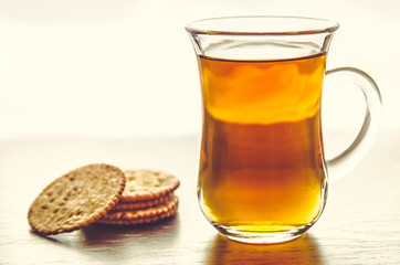 Tea cup with menbrillo cookies on bright silver background