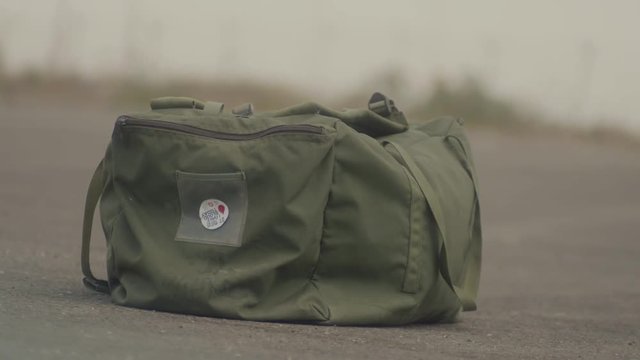 Military bag falling to the ground
