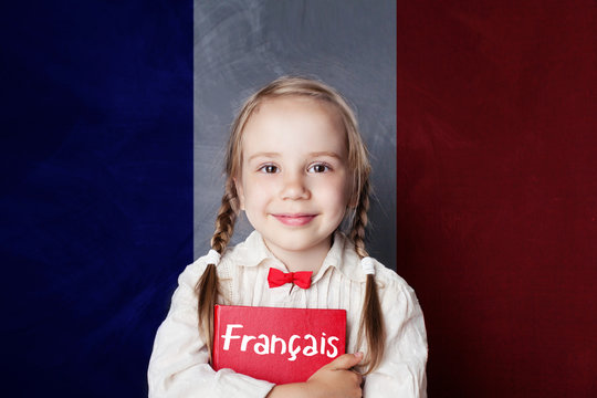 Smiling girl with book against French flag banner. Learning french
