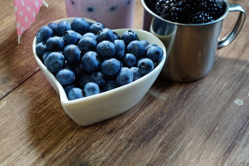 Close-up of  juicy blueberries in a bowl on rustic table
