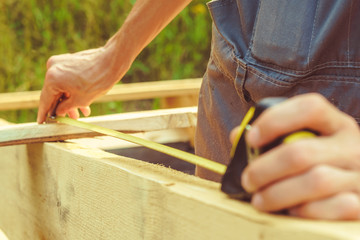 the worker makes measurements with a tape measure