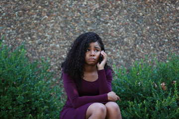 Fototapeta premium Sad black woman speaking on phone in park
