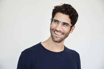 Guy in specs smiling and looking away