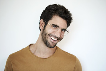 Guy in glasses smiling against white background