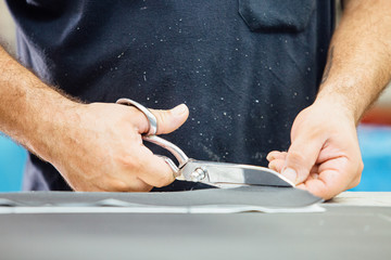 Male hands cutting the leather pattern