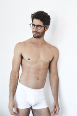 Fototapeta premium Handsome guy in glasses and underwear, looking away