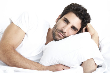 Handsome guy lying in bed, portrait