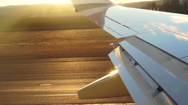 Plane wing, passenger POV taking off from runway when sunset slow motion shot