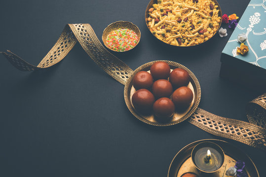 Raksha bandhan Festival : conceptual Rakhi made using plate full of Gulab Jamun sweet with band and Pooja Thali. A traditional Indian wrist band which is a symbol of love between Brothers and Sisters