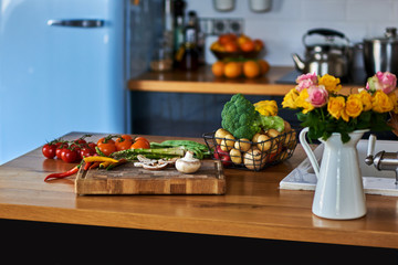 Vegetables and flowers on on rustic kitchen table.