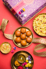 Raksha bandhan Festival : conceptual Rakhi made using plate full of Gulab Jamun sweet with band and Pooja Thali. A traditional Indian wrist band which is a symbol of love between Brothers and Sisters