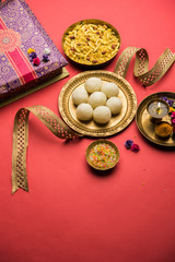 Raksha bandhan Festival : conceptual Rakhi made using plate full of Rasgulla sweet with band. A traditional Indian wrist band which is a symbol of love between Brothers and Sisters