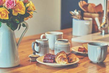 A cozy breakfast in bright colors. Croissants with cups of fresh hot coffee.