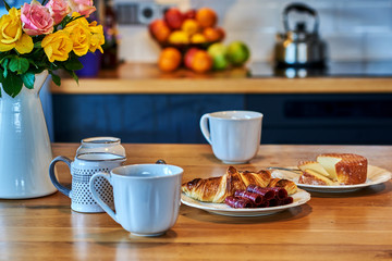 Hot tea in white cups  with fresh croissants, homemade cottage cheese and jamon.