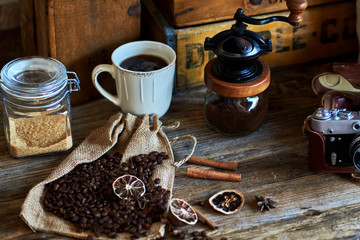 Dry orange and lemon, coffee beans in the bag, cinnamon on wooden brown background.