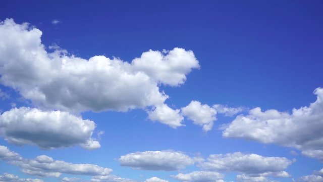 Beautiful bright blue cloudy sky background. White fluffy clouds slowly moving. Timelapse. Slow motion video footage.