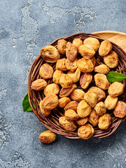 Sun dried apricots on gray concrete background. Top view.