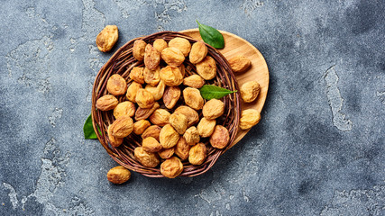 Sun dried apricots on gray concrete background. Top view of dried fruits with copy space.