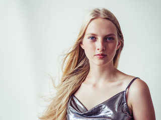 Naklejka premium Blonde long hair woman girl in silver dress over white background