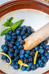 Fresh and raw blueberries ready to be crushed in jam / jam. Includes mint (mint) and lemon. On white background.
