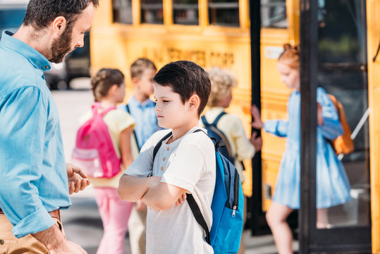 Angry Father Disciplines His Son In Front Of School Bus