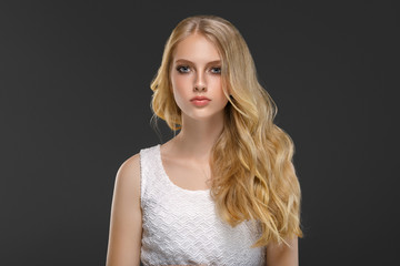 Naklejka premium Beautiful woman with long blonde hair over gray background beauty female