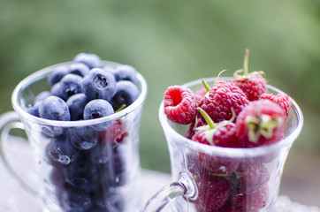A glass of sweet red raspberries and blueberries