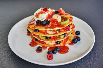 pancakes with berries, strawberry, kiwi in syrup and ice cream