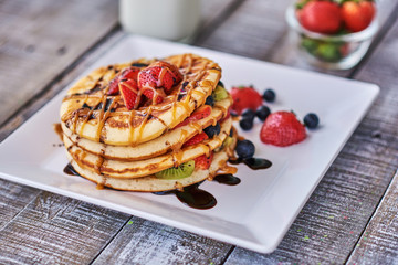 Pancakes with strawberry and caramel syrup on top