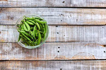 Green peas on a wooden table.
