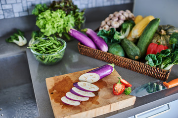 Organic vegetables eggplant on a wooden chopping board.