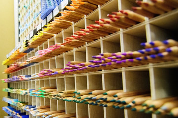 Many colored pencils on the counter in the store for drawing (painting). Accessories, chancery, drawing. Colorful background.