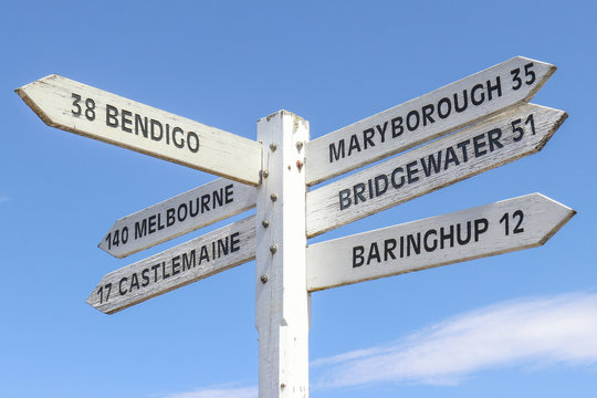 Naklejki painted wooden signpost at Maldon town centre showing distance and directions to surrounding towns and a blue sky