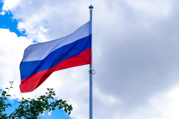 The flag of Russia against the cloudy sky