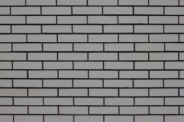 The wall of the house is lined with gray bricks. Used as a background.
