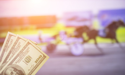 Money dollars on the background of a TV on which show sport trotting, sports betting, bookmaker, dollars