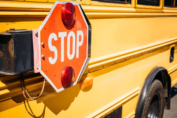 partial view of school bus with stop sign - obrazy, fototapety, plakaty
