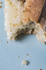 Cheese sandwich close up on a blue dish with crumbs and bitten