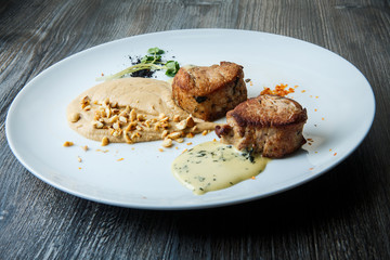 two tasty pieces of grilled meat with puree and sauce